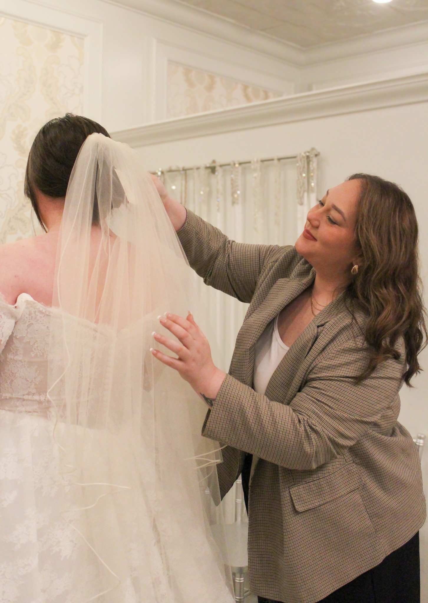 A Love Curvy Bridal stylist arranging a bride’s veil